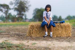 asiatischer Student in Uniform, der in der Landschaft von Thailand studiert foto