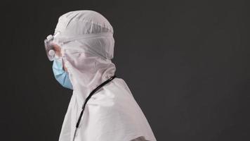 Arzt im Schutzanzug gegen Coronavirus, Maske, Brille und Stethoskop. Medizin und Gesundheitswesen foto