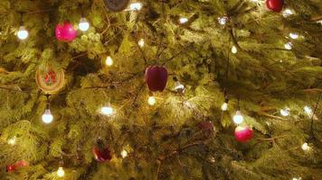 Schließen Sie einen Weihnachtsbaum, der nachts glitzert. Tannenbaum des neuen Jahres mit Dekorationen und Beleuchtung. foto