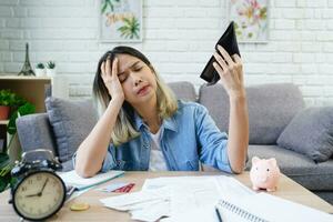 arbeitslos asiatisch Frau ist Öffnung leeren Geldbörse. sie war betont weil von Nein Geld zu Zahlen ihr Anerkennung Karte Schulden. foto