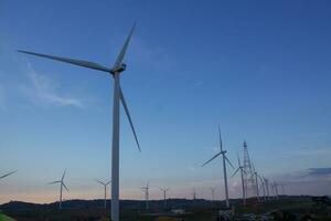 Wind Turbinen beim Sonnenuntergang mit ein schön Himmel im das Hintergrund. das Konzept von verlängerbar Energie. foto