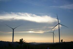 Wind Turbinen beim Sonnenuntergang mit ein schön Himmel im das Hintergrund. das Konzept von verlängerbar Energie. foto