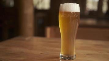 Bier. kaltes Craft Light Bier in einem Glas mit Wassertropfen. Pint Bier hautnah auf einem hölzernen Hintergrund. Grenzgestaltung. foto