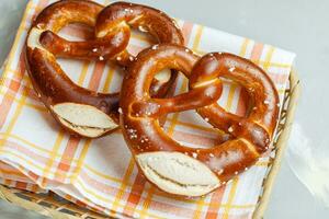 zwei hausgemacht frisch gebacken Sanft Brezeln im Brot Korb mit Serviette. traditionell bayerisch Brezel zum Oktoberfest. oben Sicht, Nahansicht foto