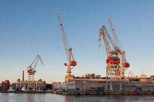 Meer Hafen Kräne mit Blau wolkig Himmel im Hintergrund und Wasser im Vordergrund im Helsinki Hafen, Finnland foto