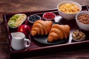 leckeres Frühstück mit frischen Croissants und reifen Beeren foto