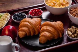 leckeres Frühstück mit frischen Croissants und reifen Beeren foto