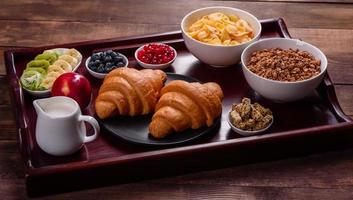 leckeres Frühstück mit frischen Croissants und reifen Beeren foto