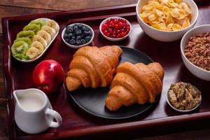 leckeres Frühstück mit frischen Croissants und reifen Beeren foto