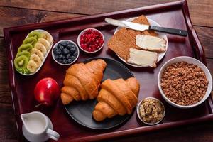 leckeres Frühstück mit frischen Croissants und reifen Beeren foto