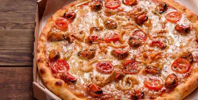 leckere Pizzascheiben mit Meeresfrüchten und Tomaten auf Betonuntergrund foto