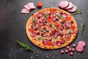 Peperonipizza mit Mozzarella, Salami und Schinken foto