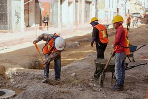 Puebla, Mexiko 2023 - - Konstruktion Arbeitskräfte Arbeit zu Reparatur ein Straße im das historisch Center von puebla foto