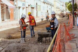 Puebla, Mexiko 2023 - - Konstruktion Arbeitskräfte Arbeit zu Reparatur ein Straße im das historisch Center von puebla foto