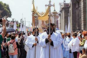 Puebla, Mexiko 2023 - - Priester und Mitglieder von das katholisch Kirche tragen aus ein Prozession im Vorderseite von das Kathedrale von Puebla. Anbetung von katholisch Christian Symbole foto