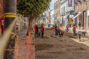 Puebla, Mexiko 2023 - - Konstruktion Arbeitskräfte Arbeit zu Reparatur ein Straße im das historisch Center von puebla foto