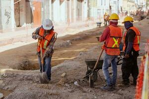 Puebla, Mexiko 2023 - - Konstruktion Arbeitskräfte Arbeit zu Reparatur ein Straße im das historisch Center von puebla foto