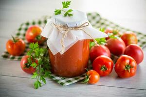 gekocht hausgemacht Tomate Saft Dosen- im ein Krug von natürlich Tomaten. foto