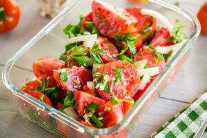 würzig Snack Tomaten mit Knoblauch, Kräuter, Gewürze und Zwiebeln im ein Glas Schüssel . foto