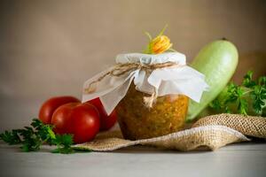 gekocht Zucchini Kaviar mit Tomaten im ein Glas Krug,. foto