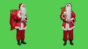 jung Mann Tanzen auf Lieder im Studio, Schauspielkunst mögen Vater Weihnachten und Hören zu Musik- auf Kopfhörer. modern Heilige Nick Charakter genießen tanzen bewegt sich mit Audio- Headset, rot Kostüm. foto