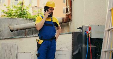 erfahren Ingenieur auf das Telefon mit Zuhause Inhaber nach Fertigstellung hvac System Reparaturen. Experte Handwerker Berufung Klient zu informieren ihm Über gebaut oben Schichten von Schmutz gefunden auf Luft Conditioner Einheit foto