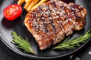 Ribeye Steak mit Kartoffeln, Zwiebeln und Cherrytomaten foto