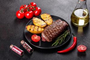 Ribeye Steak mit Kartoffeln, Zwiebeln und Cherrytomaten foto