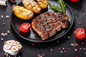 Ribeye Steak mit Kartoffeln, Zwiebeln und Cherrytomaten foto