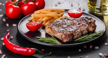 Ribeye Steak mit Kartoffeln, Zwiebeln und Cherrytomaten foto