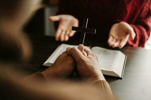 zwei Menschen lesen und Studie Bibel im Zuhause und beten zusammen.lernen das Wort von Gott mit Freunde. im Sonne Licht foto