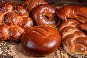 Komposition aus frisch gebackenen süßen Brötchen mit Mohn und Marmelade foto