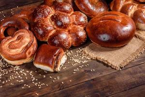 Komposition aus frisch gebackenen süßen Brötchen mit Mohn und Marmelade foto