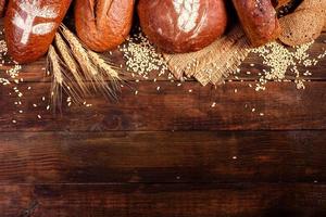 frisch gebackenes Schwarzbrot auf braunem Holzhintergrund foto