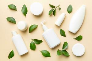 organisch kosmetisch Produkte mit Grün Blätter auf Farbe Hintergrund. eben legen foto