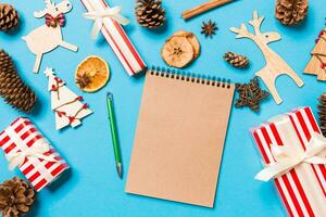 Draufsicht des Notebooks auf blauem Hintergrund aus Weihnachtsschmuck. neujahrszeitkonzept foto