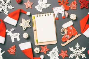 Draufsicht des Notizbuchs. neujahrsdekorationen auf schwarzem hintergrund. Frohe Weihnachten-Konzept foto