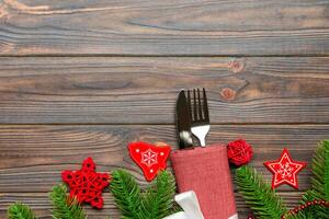 Draufsicht auf festliches Besteck auf Holzhintergrund des neuen Jahres. weihnachtsschmuck mit leerem platz für ihr design. Urlaubsdinner-Konzept foto
