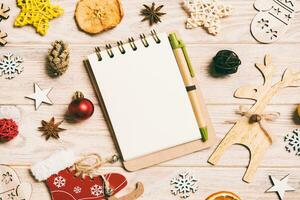 Draufsicht des Notebooks auf Holzhintergrund aus Weihnachtsschmuck. Neujahrskonzept foto