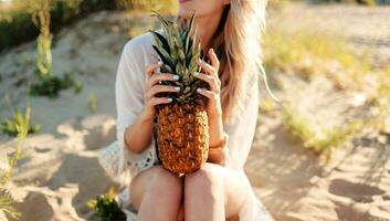 Lebensstil draussen Bild von Frau mit saftig Ananas entspannend auf sonnig Strand. foto