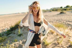 anmutig blond Mädchen auf modisch Boho Strand Startseite mit Franse und Zubehör auf tolle einsam Strand foto