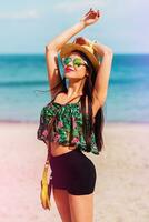 draussen Sommer- Lebensstil Porträt von perfekt passen lächelnd Frau mit perfekt Körper haben Spaß auf das tropisch Strand tragen Stroh Hut. hell Farben. glücklich Stimmung. foto