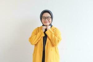 jung schön asiatisch Muslim Frau, tragen Brille und Gelb Blazer mit glücklich lächelnd Gesicht Ausdruck foto