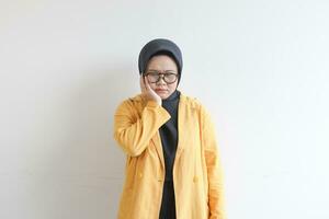 jung schön asiatisch Muslim Frau, tragen Brille und Gelb Blazer mit traurig Ausdruck weil von Zahnschmerzen foto