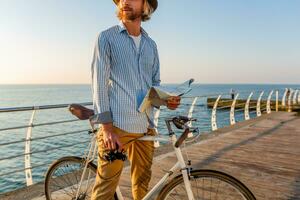 jung attraktiv Mann Reisen auf Fahrrad durch Meer foto
