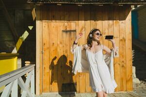 schön Frau im Weiß Sommer- Kleid durch das Meer foto