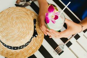 attraktiv jung Frau im Blau Kleid und Stroh Hut tragen Rosa Sonnenbrille Trinken Cocktails foto