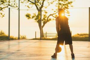 schwarz Mann tun Sport, spielen Basketball auf Sonnenaufgang, aktiv Lebensstil, sonnig Sommer- Morgen foto