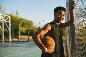 schwarz Mann tun Sport, spielen Basketball auf Sonnenaufgang, aktiv Lebensstil, sonnig Sommer- Morgen foto