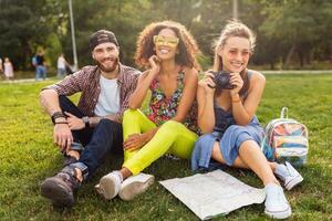 glücklich jung Unternehmen von reden lächelnd freunde Sitzung Park foto